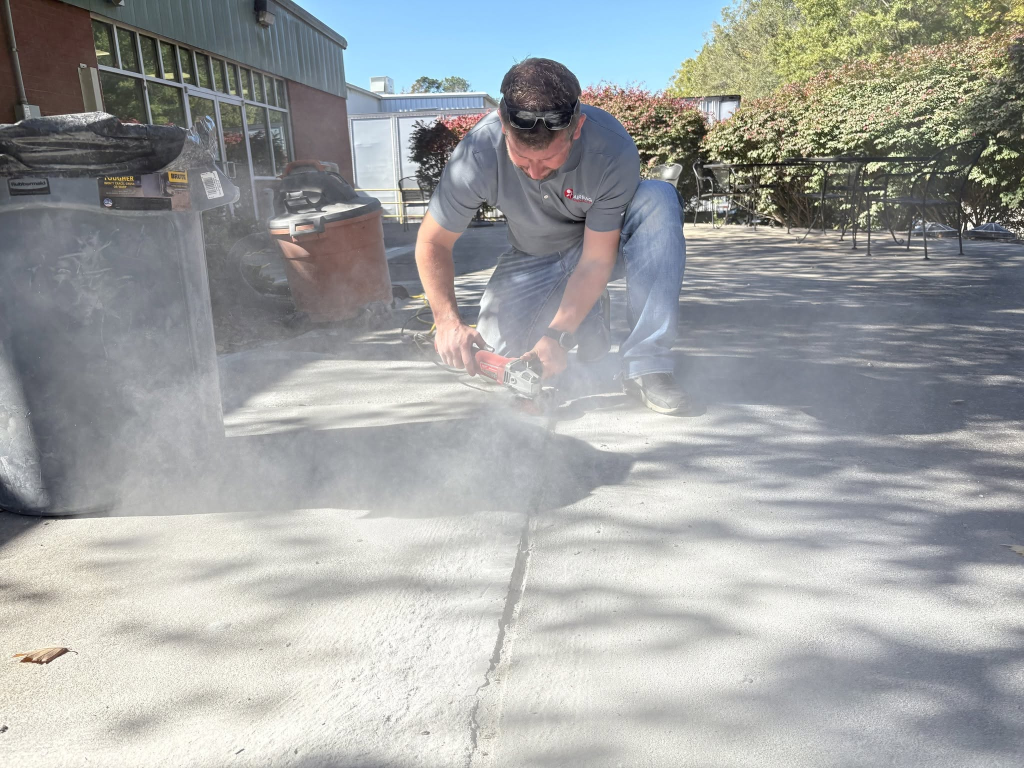 Technician using angle grinder to prepare concrete joint