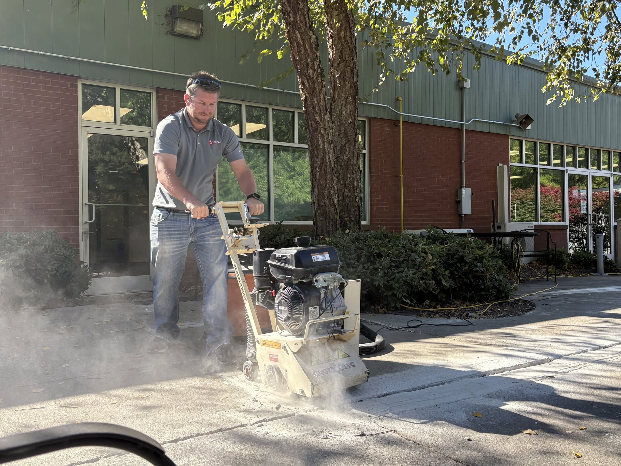 Technician using floor grinder on commercial concrete