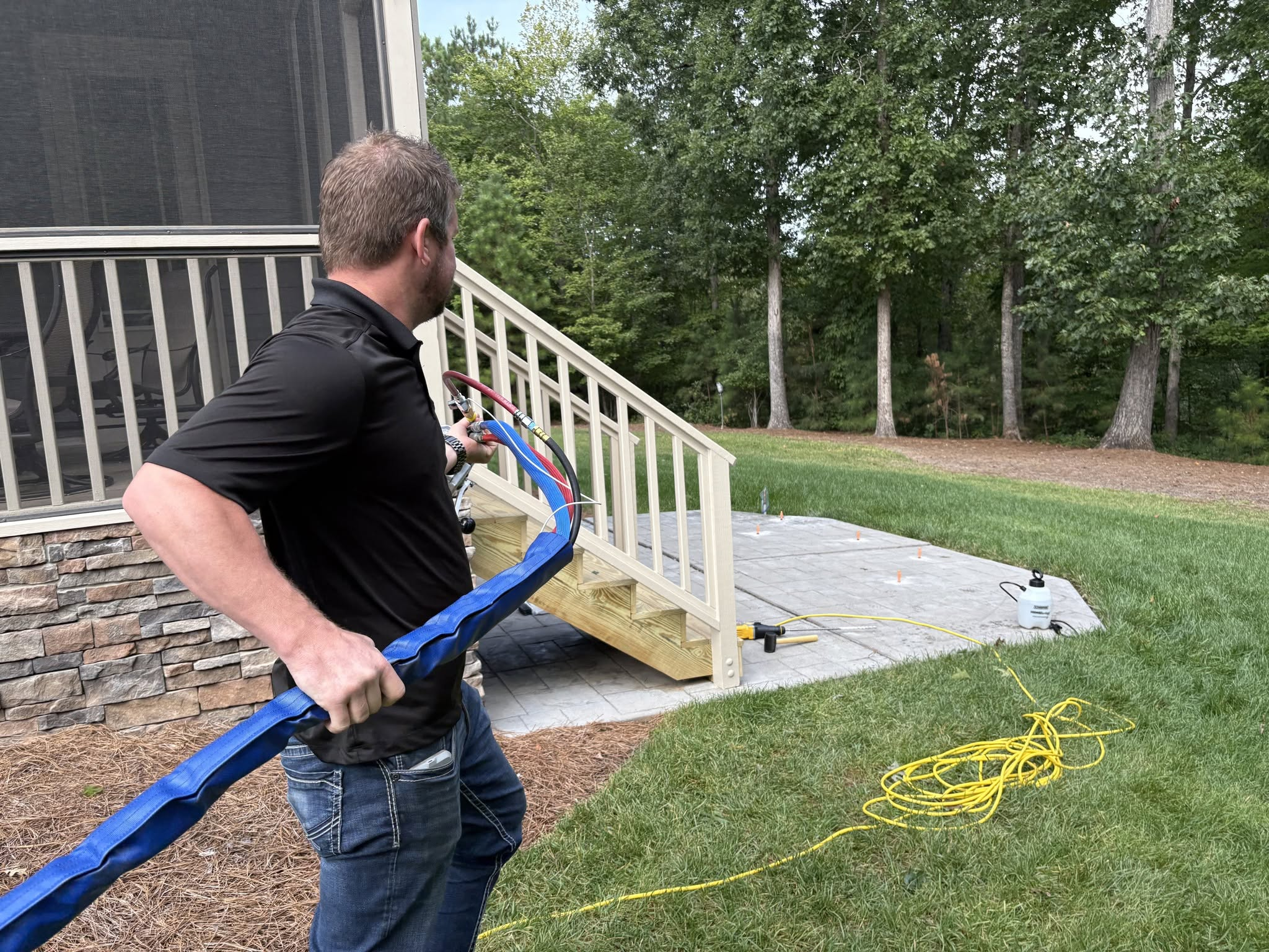 Technician feeding foam injection hose at job site
